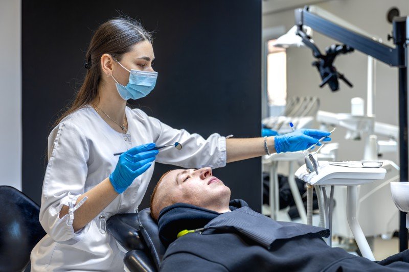 Cosmetic Dentist in Manesar examining a patient's teeth during a smile enhancement consultation.