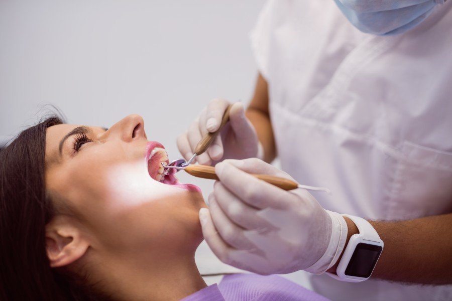 Dentist examining a female patient’s teeth during a dental checkup