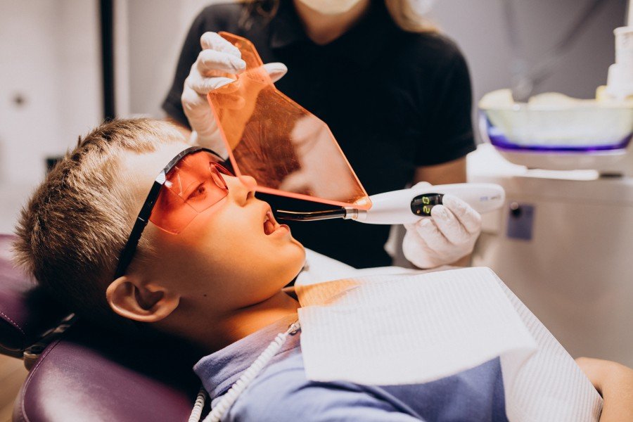 Child undergoing a dental treatment with protective eyewear in a dental clinic