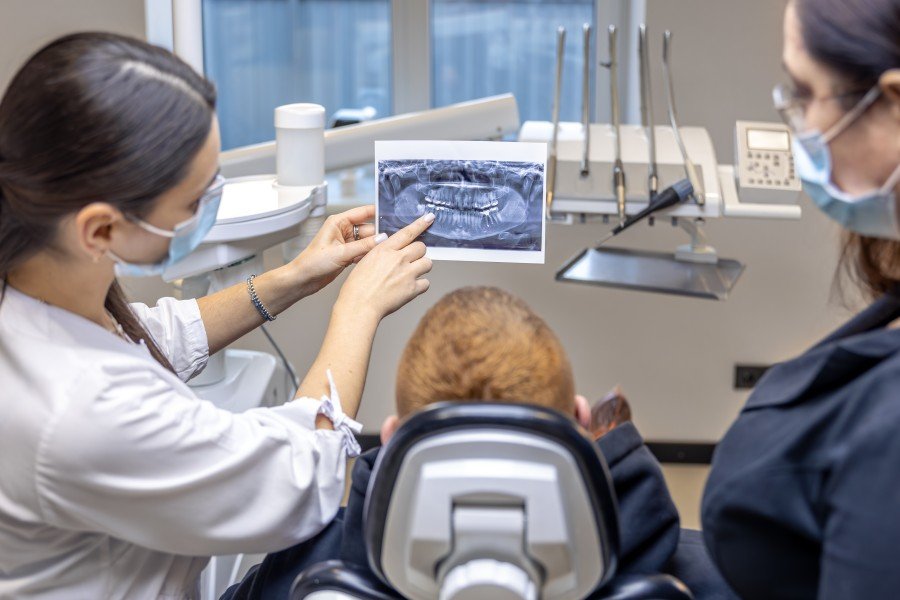 Dentist explaining a dental X-ray to a patient at a Dental Implant Clinic.